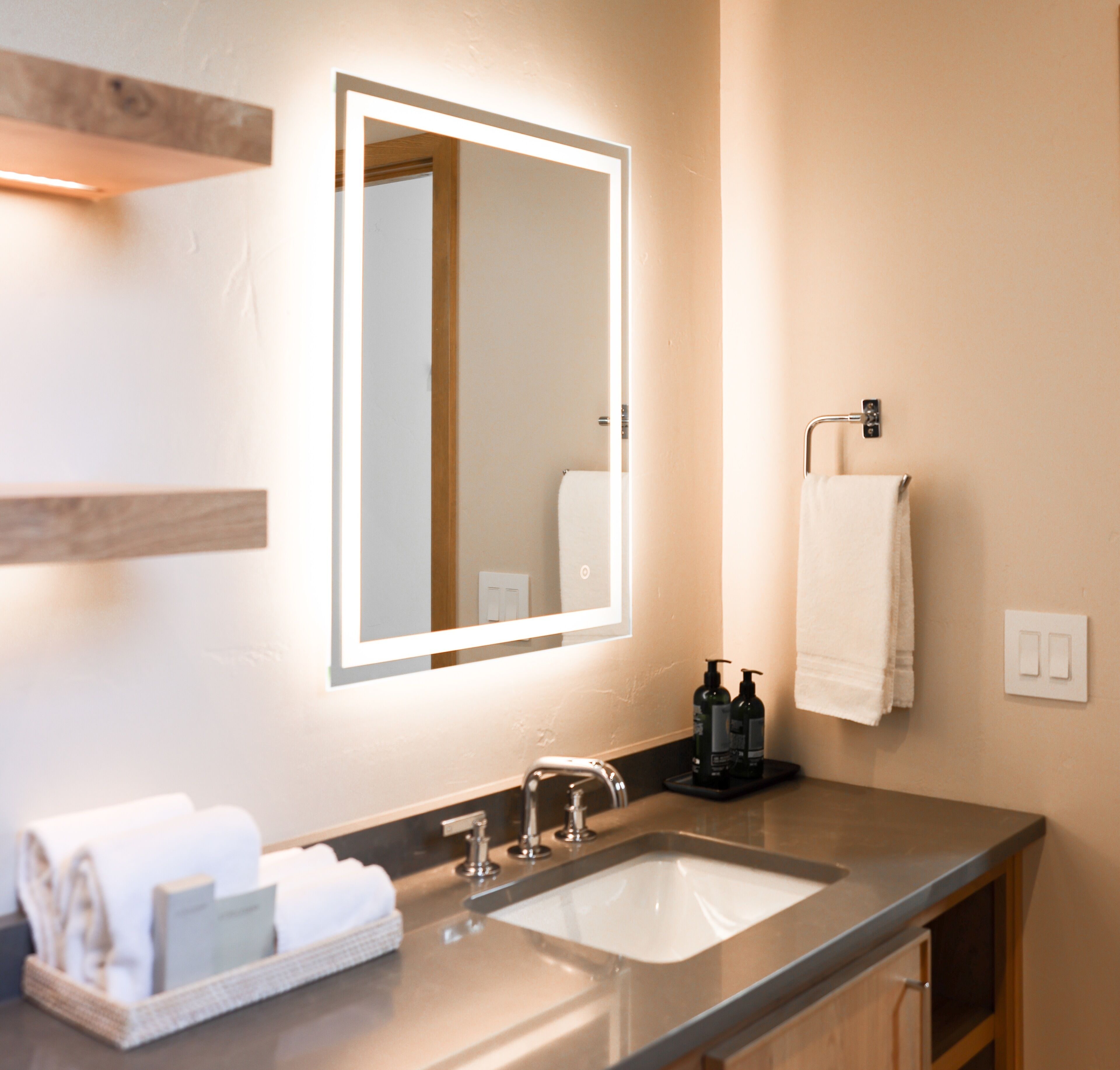 Un baño moderno con un espejo grande, un lavabo y un perchero para toallas.