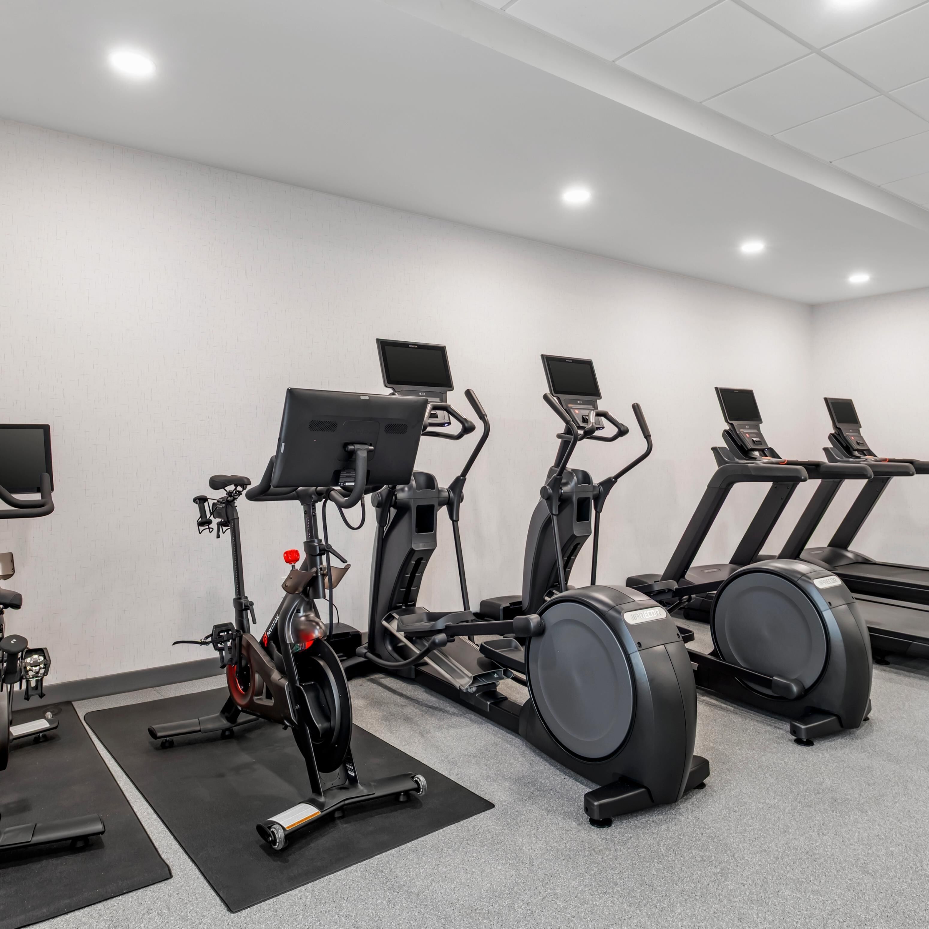 A gym with stationary bikes, elliptical machines, and treadmills.