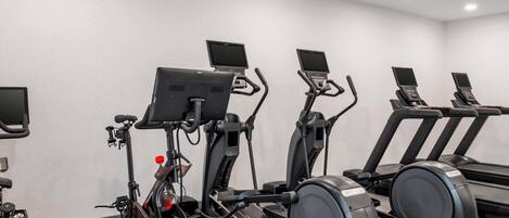 A gym with stationary bikes, elliptical machines, and treadmills.