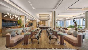 Een moderne hotellobby met zitgedeeltes, een receptiebalie en een bar.