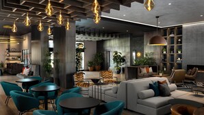 A modern lounge area with seating arrangements, pendant lighting, and a fireplace. - Hotel Avail Rogers, Tapestry Collection By Hilton (Rogers)