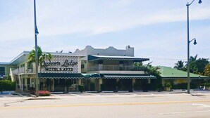 A two-story building with a sign that reads "Queen's Lodge Hotel & Arts." - Queens Lodge Motel (West Palm Beach)