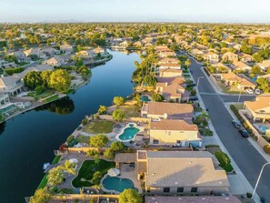 A residential area with houses, a canal, and a swimming pool.