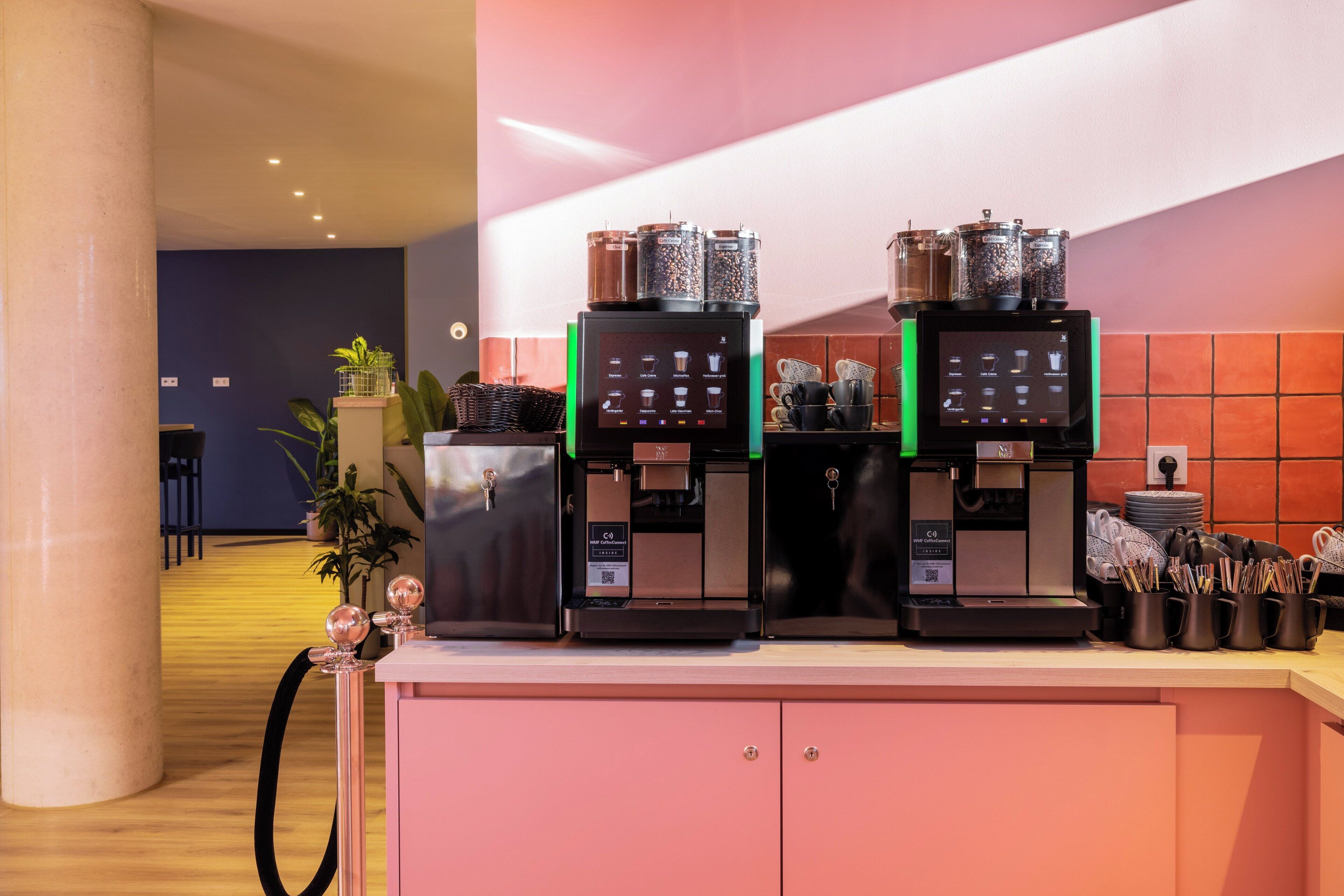 Een koffiehoek met twee espresso machines en een selectie koffiebonen.