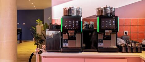 Una estación de café con dos máquinas de espresso y una variedad de granos de café exhibidos.