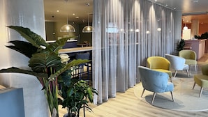 Ein modernes Interieur mit einer Sitzecke, einem Empfangsbereich und einem Essbereich.