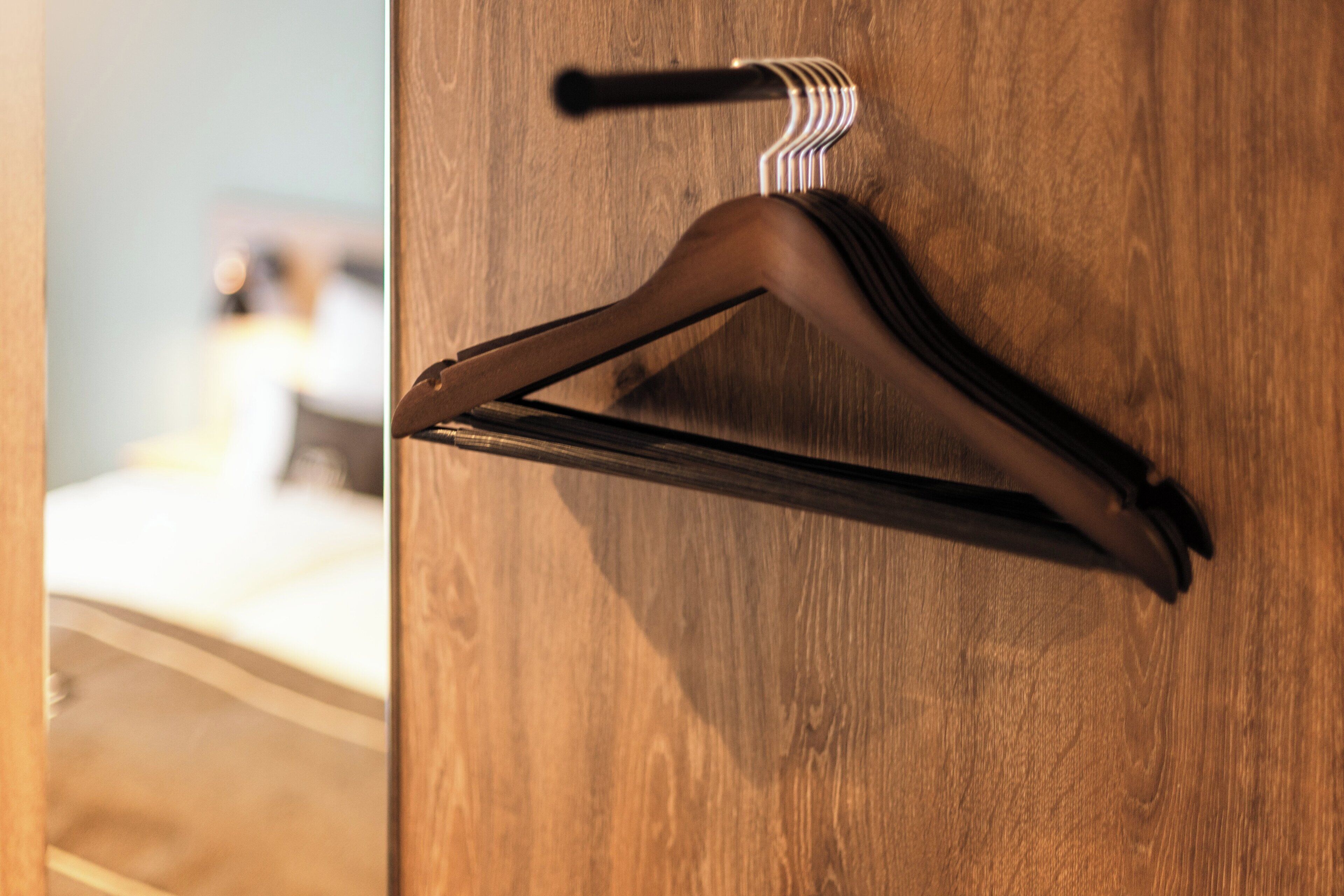A wooden door with a coat hook and a door handle.