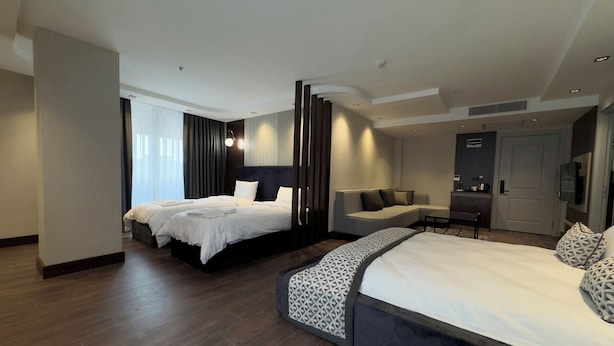 A modern hotel room with two beds, a sofa, and a desk area. - Nevizade Avangart Hotel (Istanbul)