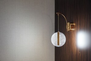 A wall-mounted light fixture with a circular shade and a curved arm, attached to a wooden wall. - Nevizade Avangart Hotel (Istanbul)