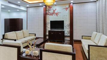 A modern living room with sofas, a coffee table, and a TV.