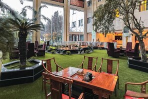 Un patio interior con zona de comedor, asientos y fuente de agua.
