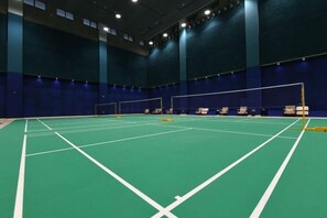 An indoor badminton court with a net, seating area, and a high ceiling. - Grand Shaanxi Hotel (Xi'an)