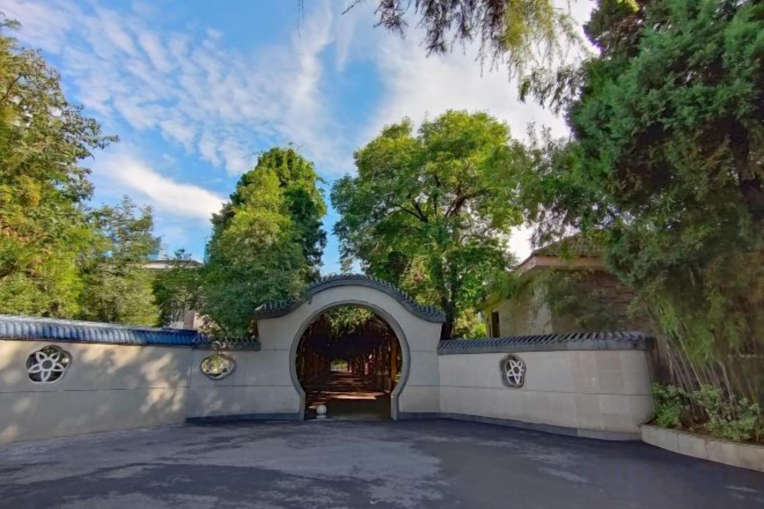 An arched entrance to a building surrounded by trees.