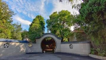 An arched entrance to a building surrounded by trees.
