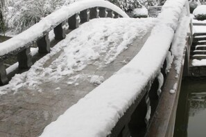 Un pont enneigé, doté de garde-corps en pierre et d’un trottoir pavé.