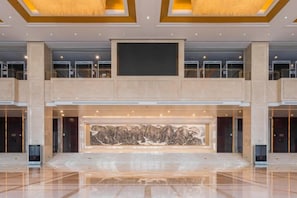 A spacious lobby with a large central artwork, multiple floors, and a modern design. - Grand Shaanxi Hotel (Xi'an)