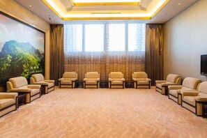 A conference room with a carpeted floor, multiple chairs arranged in rows, a large screen, and a television on the wall. - Grand Shaanxi Hotel (Xi'an)