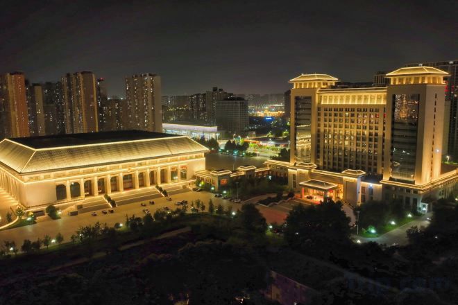 Un hotel con un edificio grande e iluminado y un patio bien iluminado.