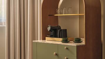 A kitchen with a wooden cabinet, a coffee maker, and a shelf with glassware.