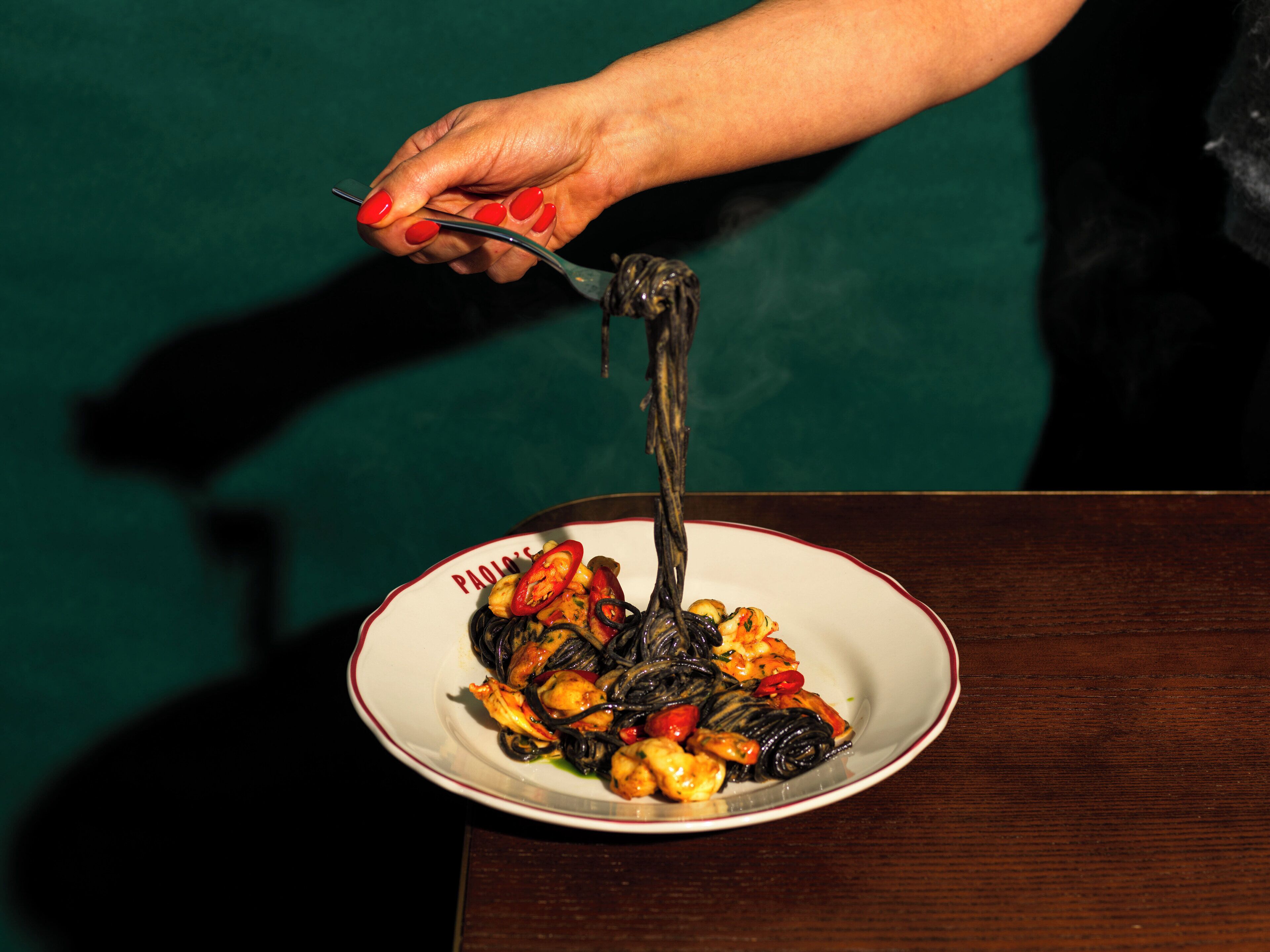 Un plato de pasta con un tenedor levantando una porción.