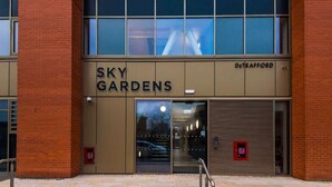 Un edificio con un cartel que dice 'SKY GARDENS' y 'DETRAFFORD' en la fachada.