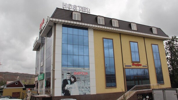 A hostel with a large sign reading "HOSTEL" and a wedding photo advertisement on the side. - Hostel Asham (Gusar)
