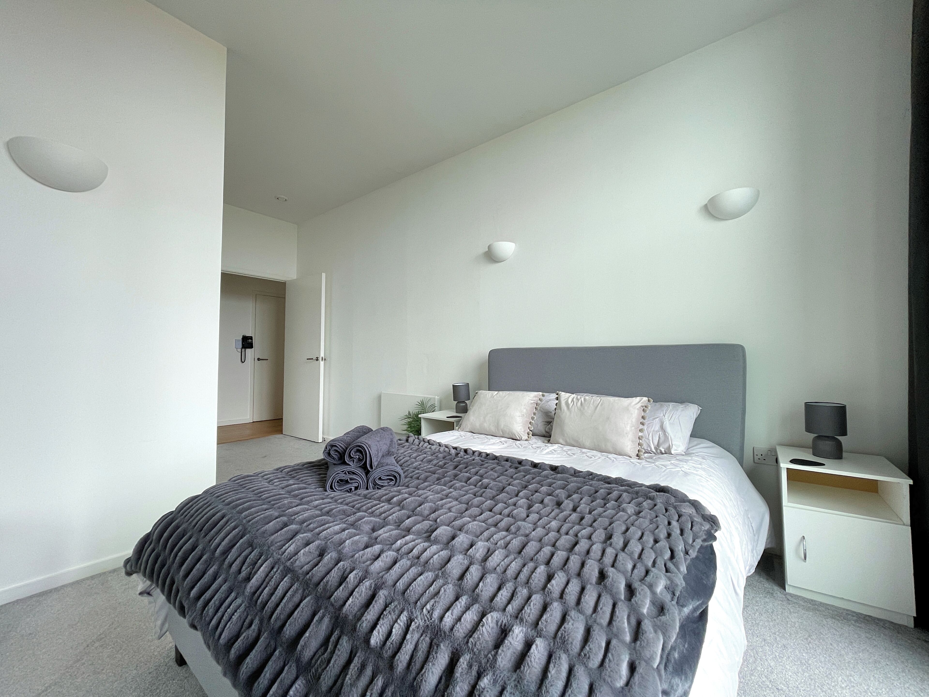 Una camera da letto moderna con un letto grande, un comodino e un tavolino.
