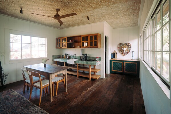 A kitchen with wooden cabinets, a dining table, and chairs. - Ibiti Village (Lima Duarte)