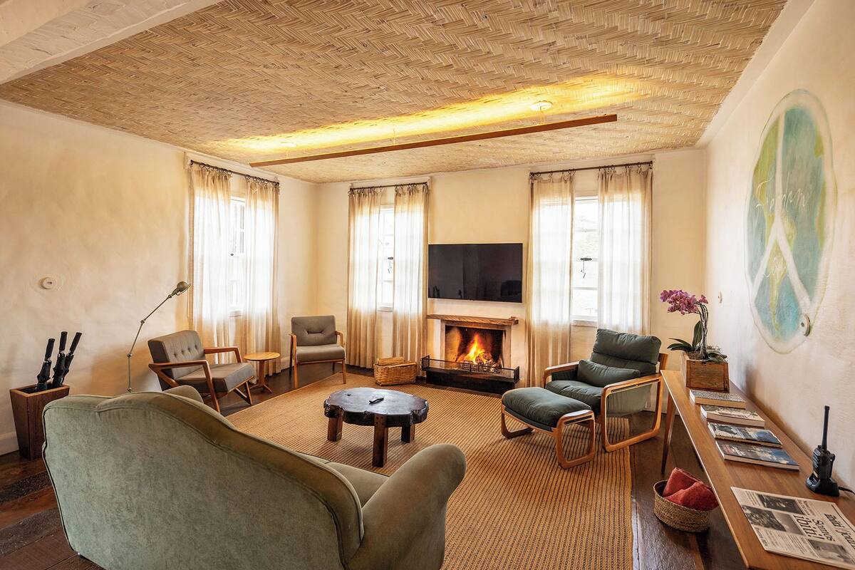 A cozy living room with a fireplace, comfortable seating, and a flat-screen TV.