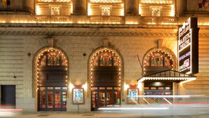 A theater with ornate architecture, large arched windows, and a marquee sign. - Downtown Boston Famous Nightlife Central Location (Boston)