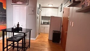 A compact living space with a kitchenette, a dining area with a table and bench, and a bed. - Downtown Boston Famous Nightlife Central Location (Boston)