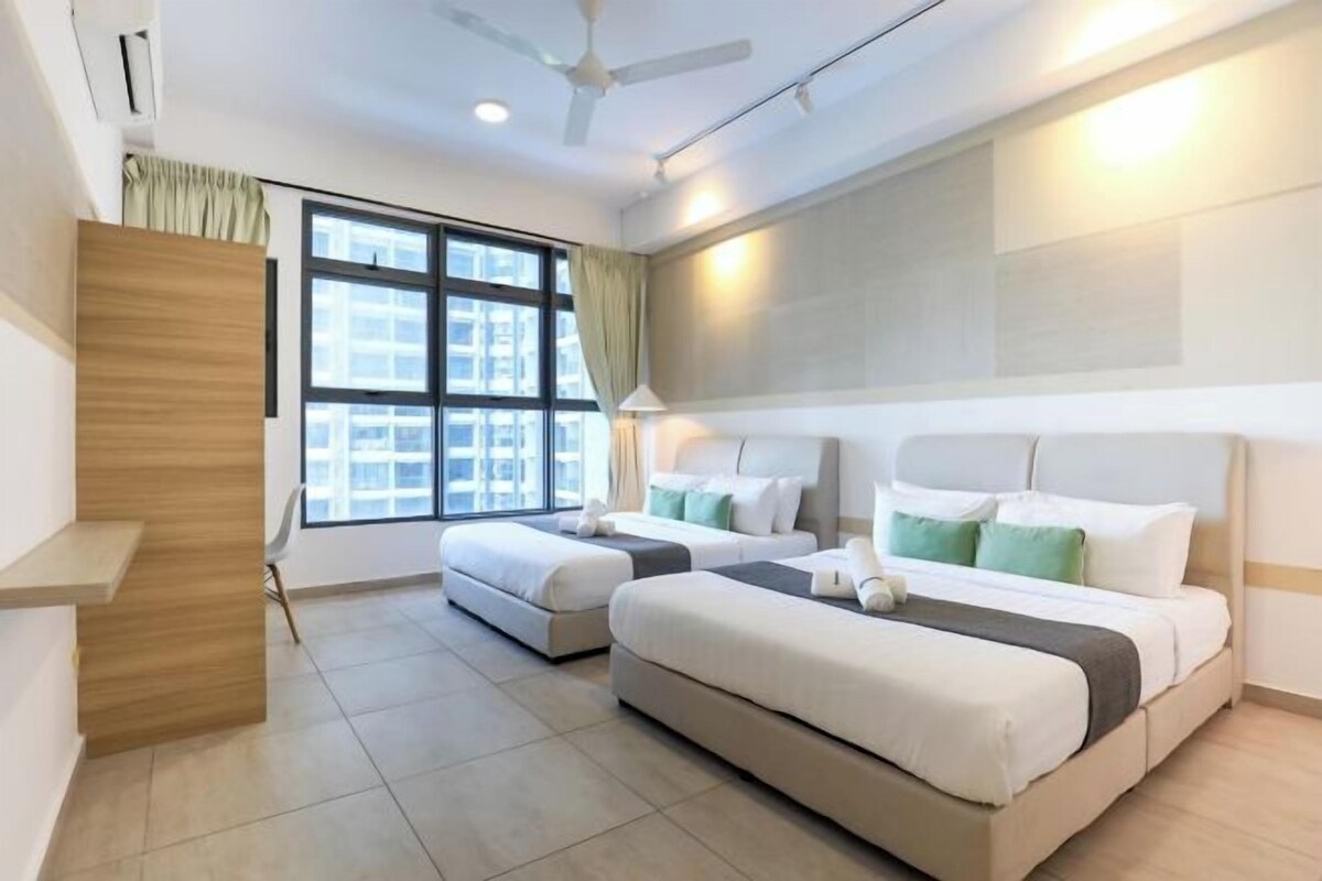 A hotel room with two beds, a desk, a chair, and a window with curtains.