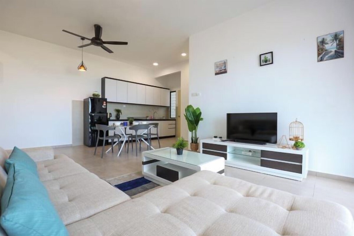 A modern living room with a sofa, a TV, and a dining area with chairs and a table.