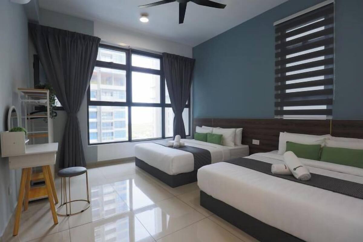 Une chambre d’hôtel avec deux lits, un bureau, une chaise et une fenêtre avec des rideaux.