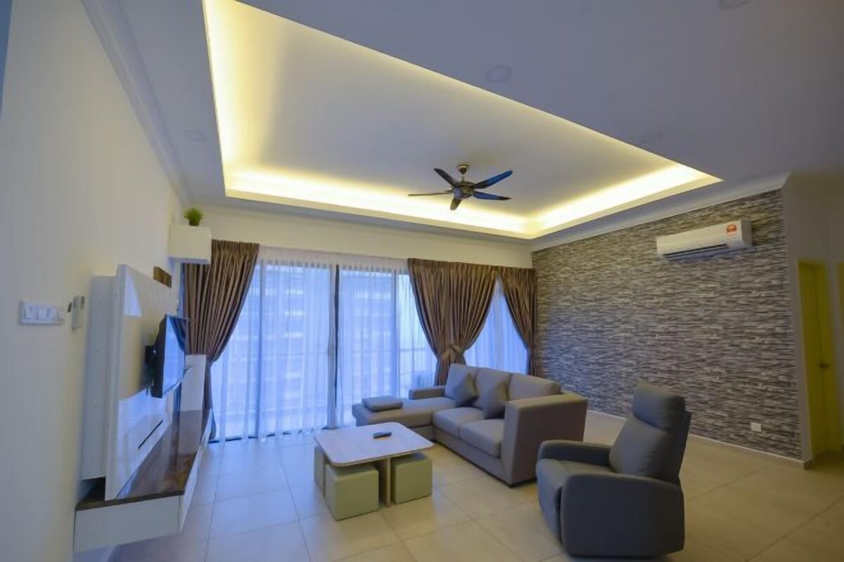 A modern living room with a flat-screen TV, sofa, armchair, and a ceiling fan.