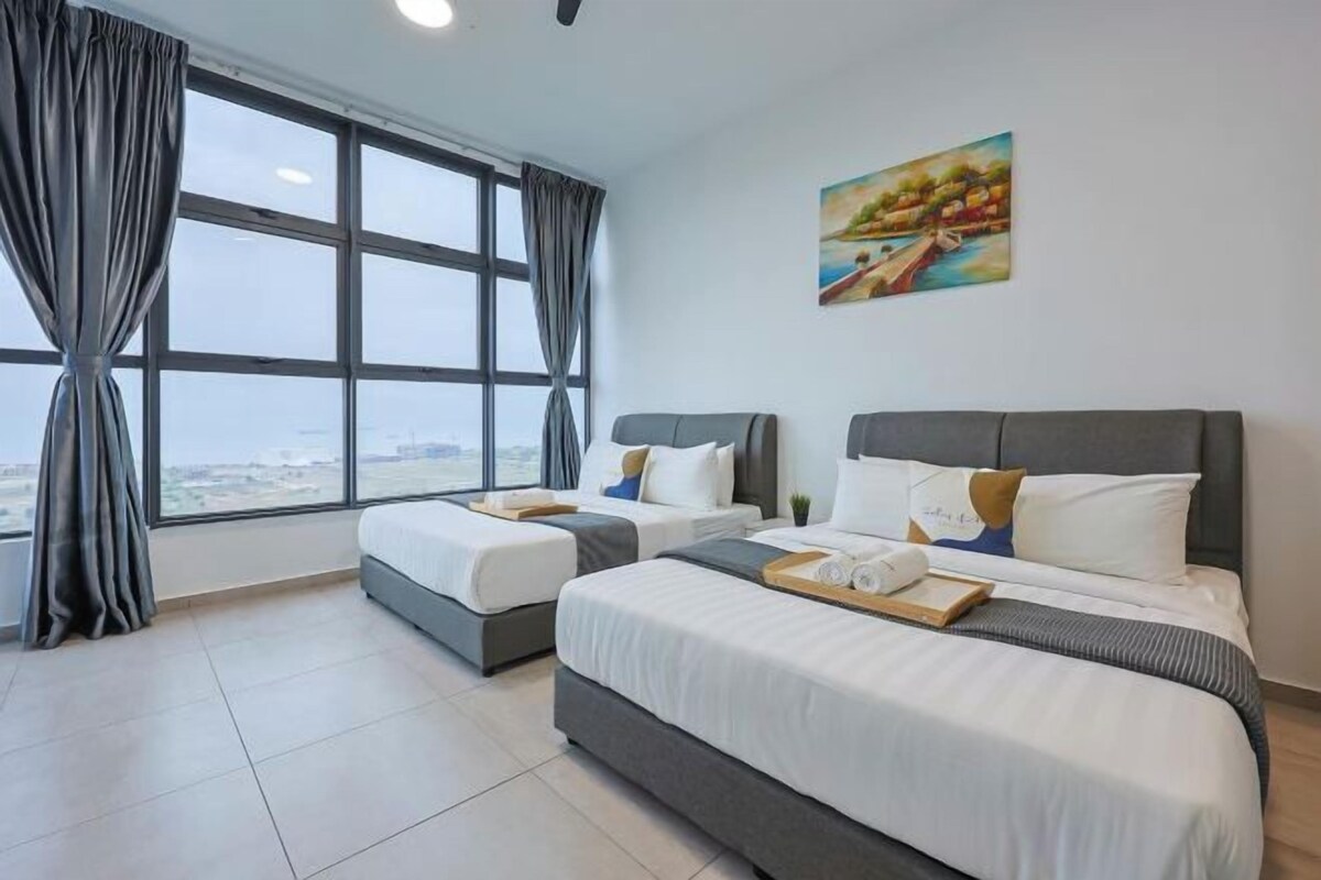 A hotel room with two beds, a large window with curtains, and a painting on the wall.