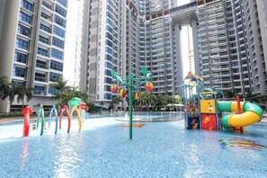 Ein Wasserpark mit Rutschen und Spielgeräten, umgeben von Hochhäusern.