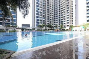 Piscina com vista para edifícios altos ao fundo.