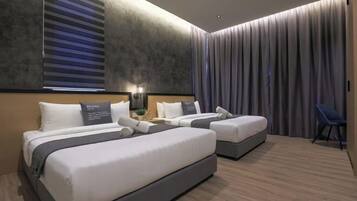 Una habitación de hotel moderna con dos camas, un ventilador de techo y un ventanal con persianas.