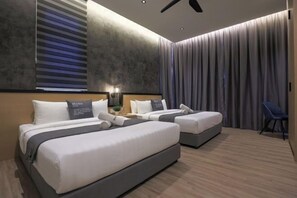 Quarto de hotel moderno com duas camas, um ventilador de teto e uma janela grande com persianas.