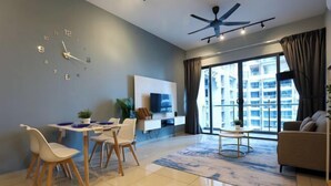 A modern living room with a dining area, a ceiling fan, a large window with curtains, and a TV mounted on the wall. - Atlantis Residence Premium By I Housing (Melaka)