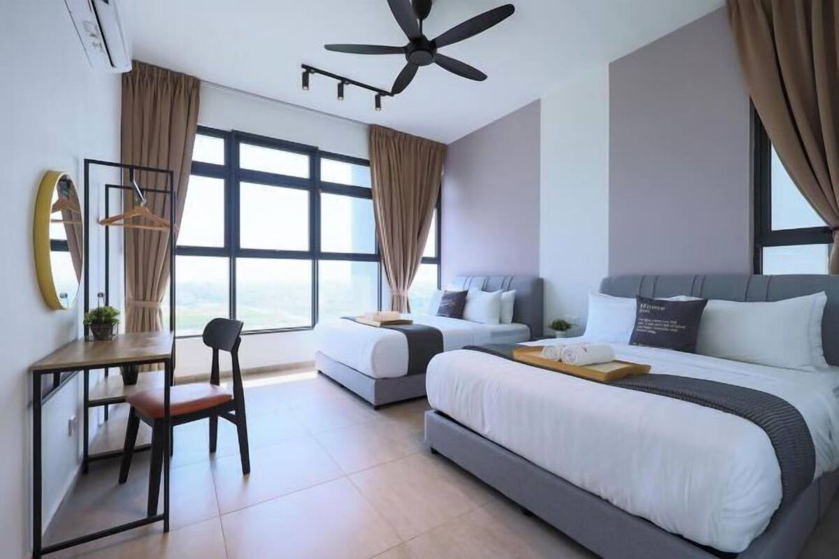 Une chambre d’hôtel avec un grand lit, un bureau, une chaise et un ventilateur de plafond.