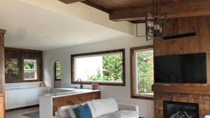 A modern living room with a sofa, a coffee table, a fireplace, and a television. - Lakefront Leisurely Hideaway - Private and Peaceful (Kincardine)