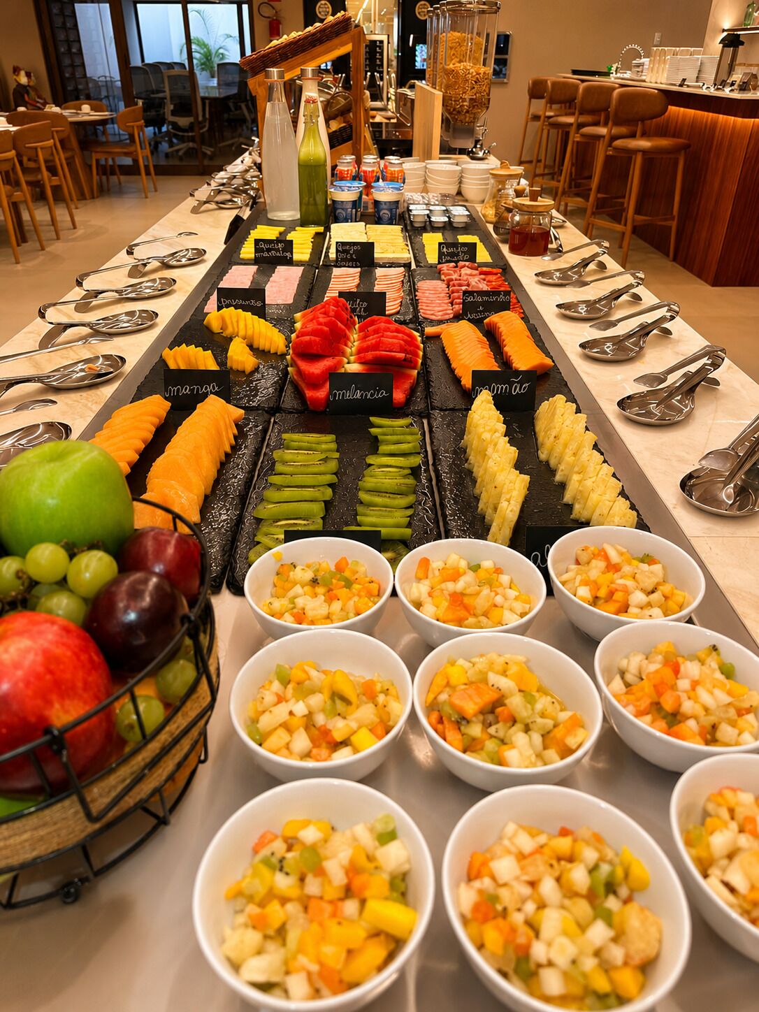 A buffet with various fruits, vegetables, and prepared dishes.