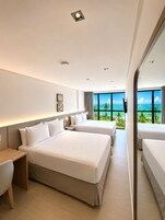 Una camera d'albergo moderna con un letto grande, una scrivania e vista sull'oceano.