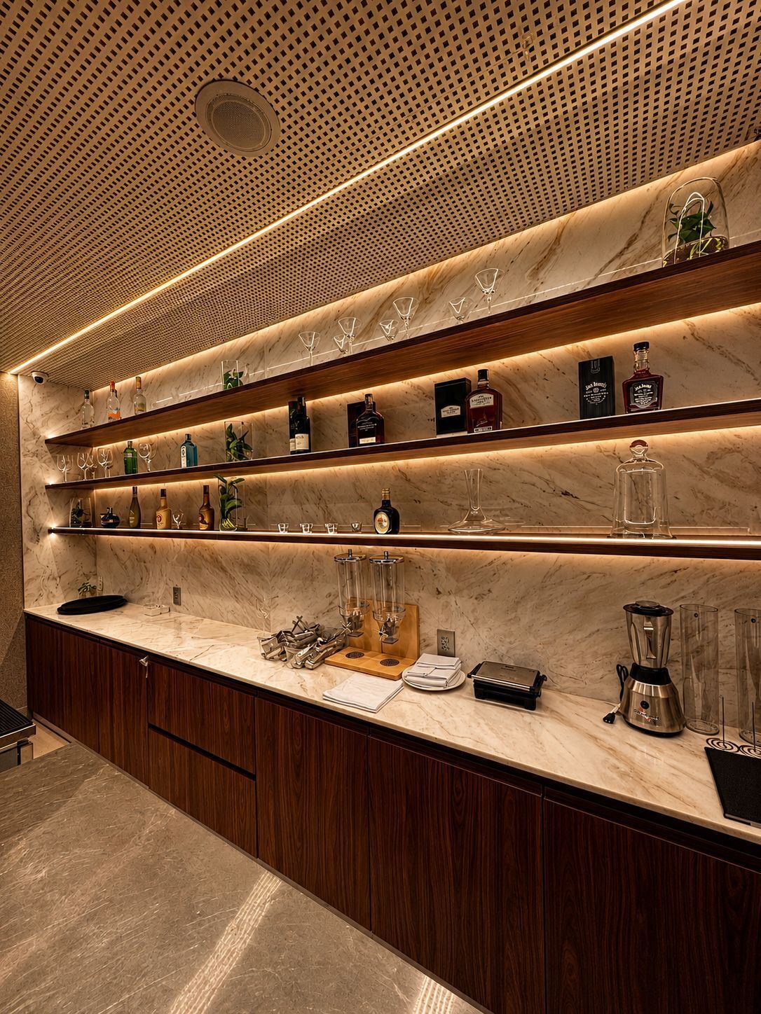A modern kitchen with marble countertops, wooden shelves, and a variety of kitchen appliances.