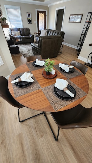 Enjoy dining in style with a round table set for four, surrounded by comfortable seating and a cozy living area.