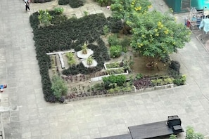 Vista aérea de un patio con jardín central, senderos y una zona de estar.