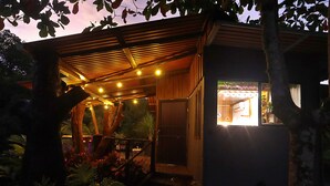 Un bâtiment en bois doté d’un espace extérieur abrité, d’une entrée bien visible et d’un intérieur éclairé.