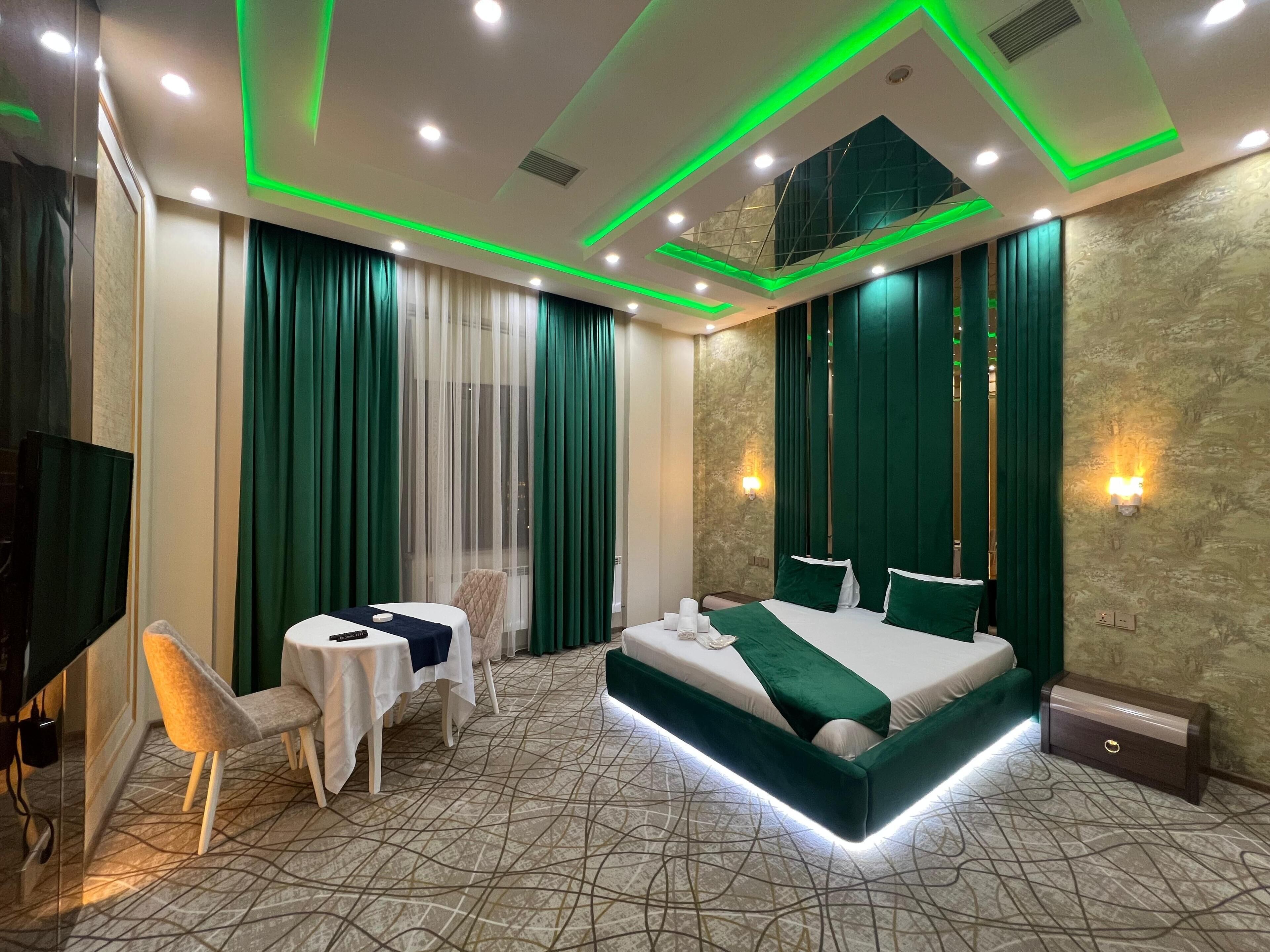 A modern hotel room with a large bed, a desk, and a chair.